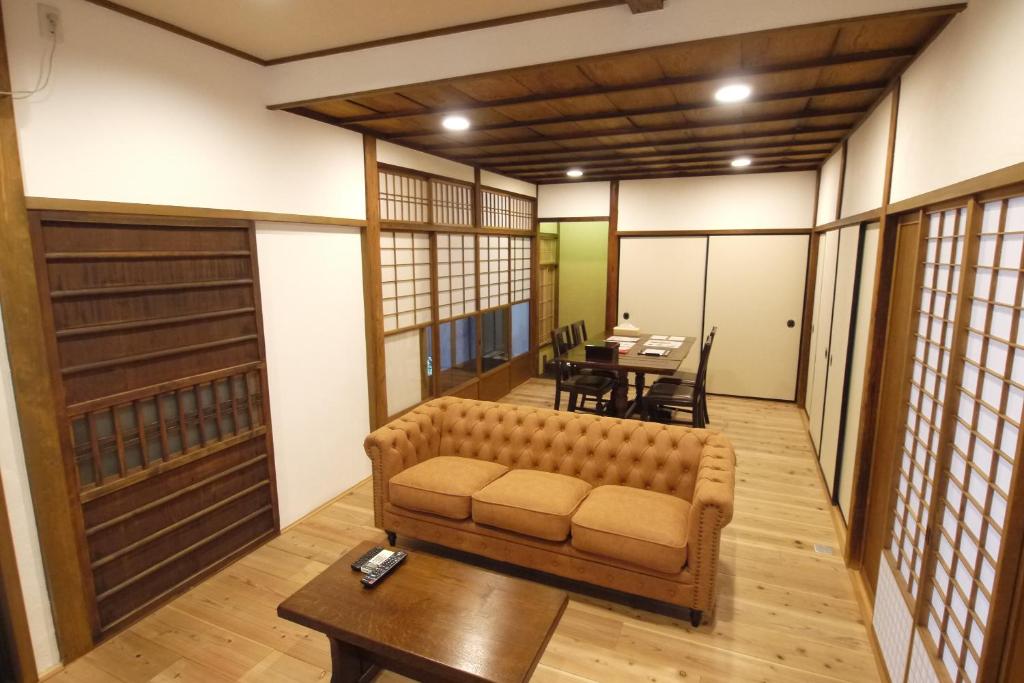 ein Wohnzimmer mit einem Sofa und einem Tisch in der Unterkunft Ichimatsu-an in Kyoto