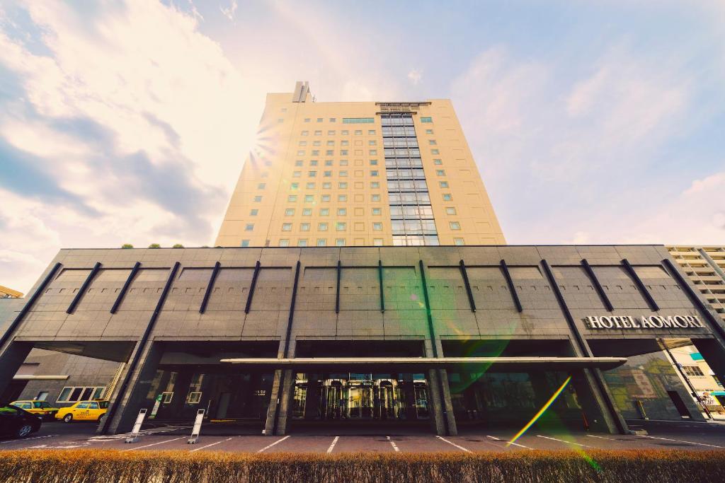 a tall building with a large building at Hotel Aomori in Aomori