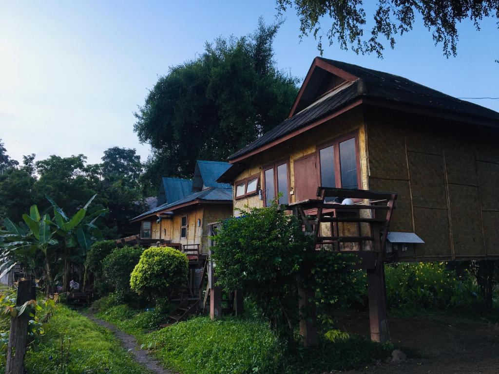 a group of cottages on a hill with a road at Golden Hut -Chill Bungalows in town黄金泰式传统独栋小屋 in Pai
