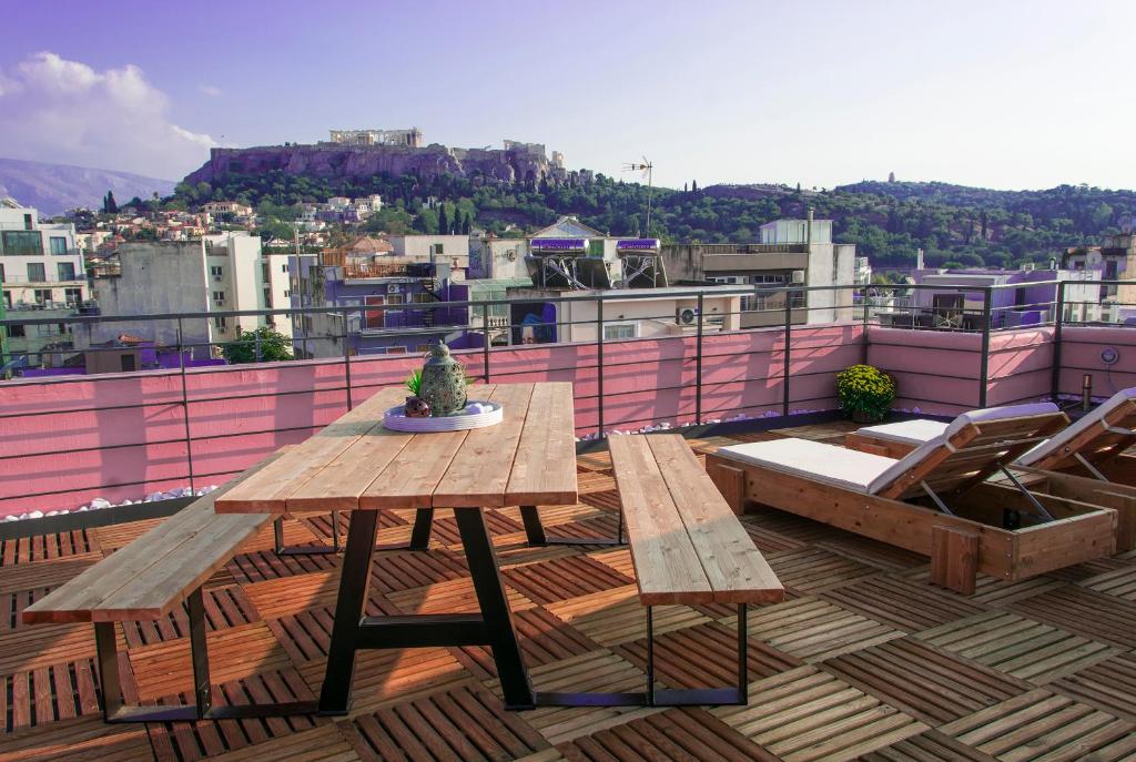 a wooden table and chairs on top of a roof at Central Stay Athens in Athens
