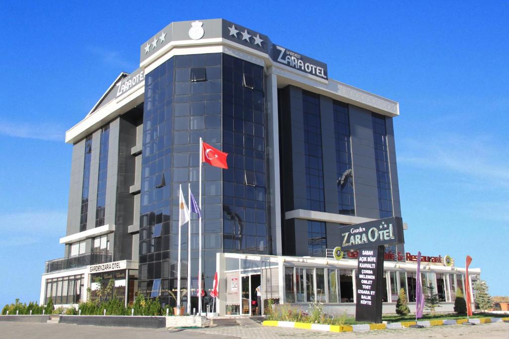 un grand bâtiment bleu arborant un drapeau canadien dans l'établissement Garden Zara Hotel, à Zara