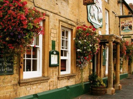 a building with flowers on the side of it at Redesdale Arms Hotel in Moreton in Marsh