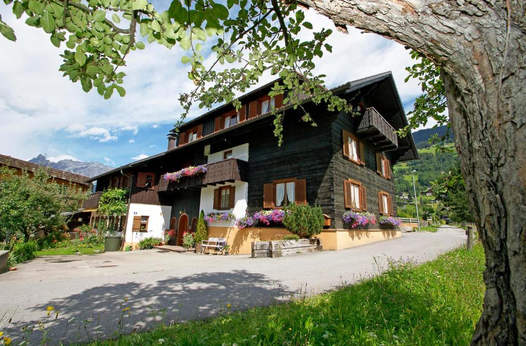 une maison dans les montagnes avec des fleurs dans l'établissement Haus Doro und Kurt, à Schruns