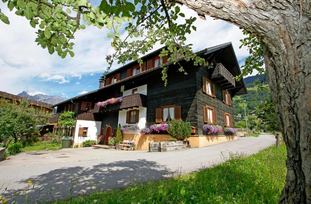 ein Haus in den Bergen mit Blumen drauf in der Unterkunft Haus Doro und Kurt in Schruns-Tschagguns