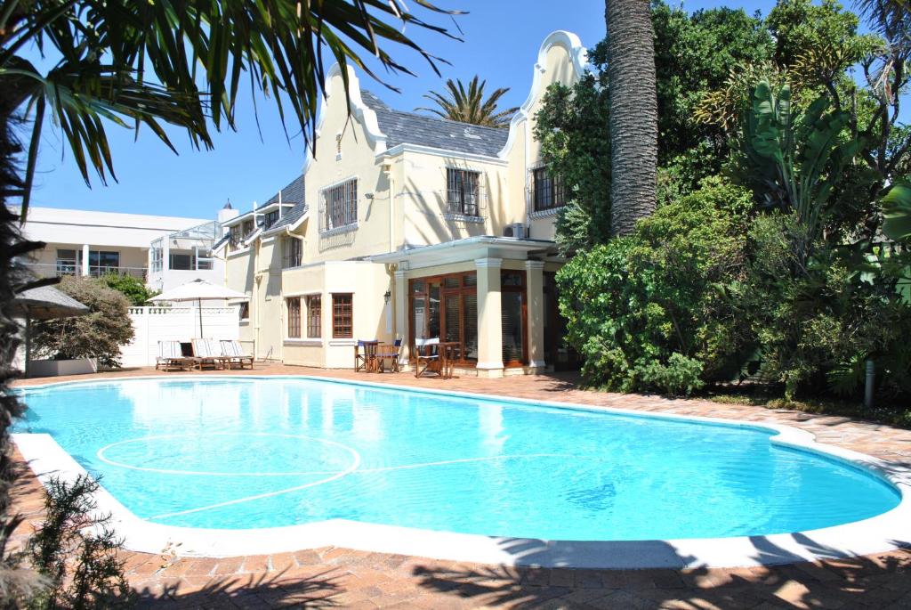 a swimming pool in front of a house at Cotswold House in Cape Town