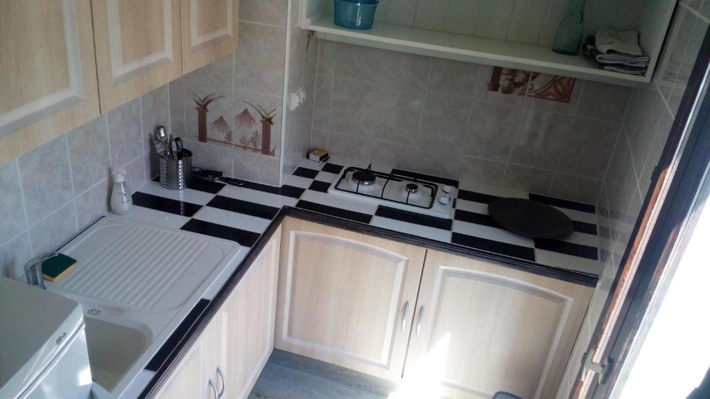 a small kitchen with a black and white counter top at Studio lumineux centre ville in Luchon