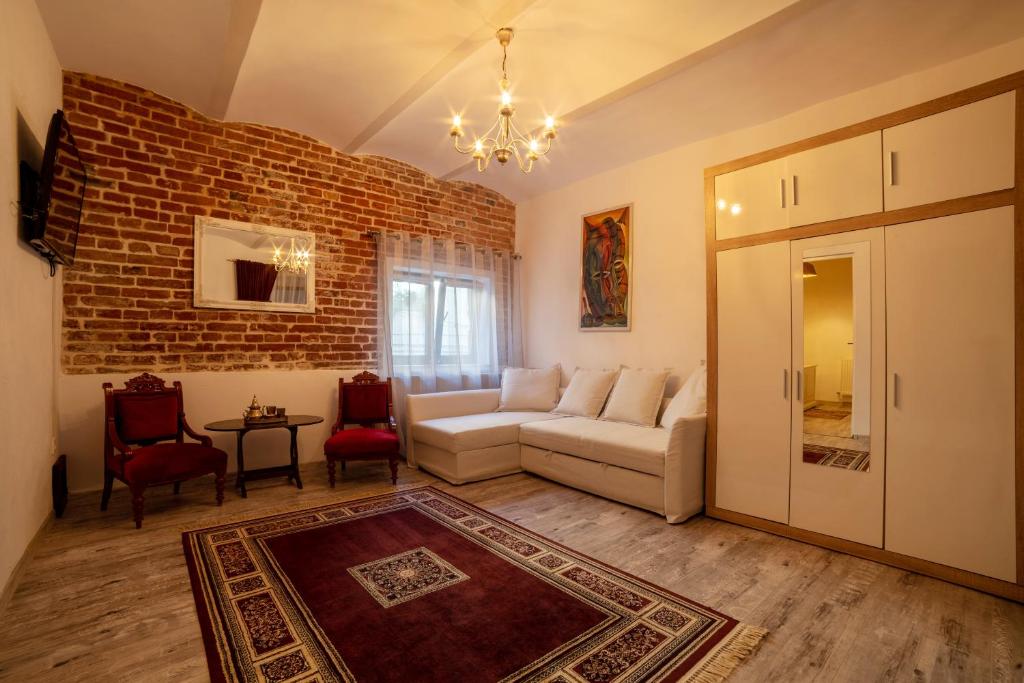 ein Wohnzimmer mit Sofa und Ziegelwand in der Unterkunft Apartament Ultra Central in Sighişoara