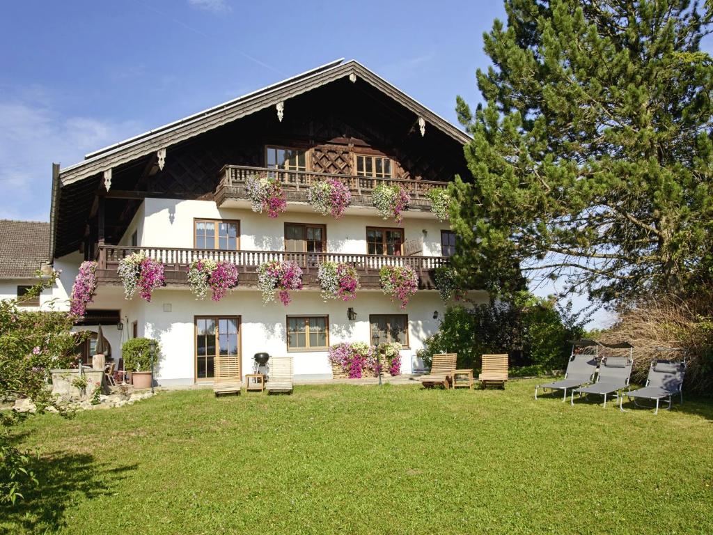 duży biały dom z balkonem z kwiatami w obiekcie Ferienhof Dirnberg w mieście Amerang