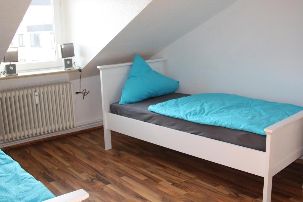 ein Schlafzimmer mit einem Bett mit blauen Kissen darauf in der Unterkunft Apartment mit Rheinblick in Wesseling