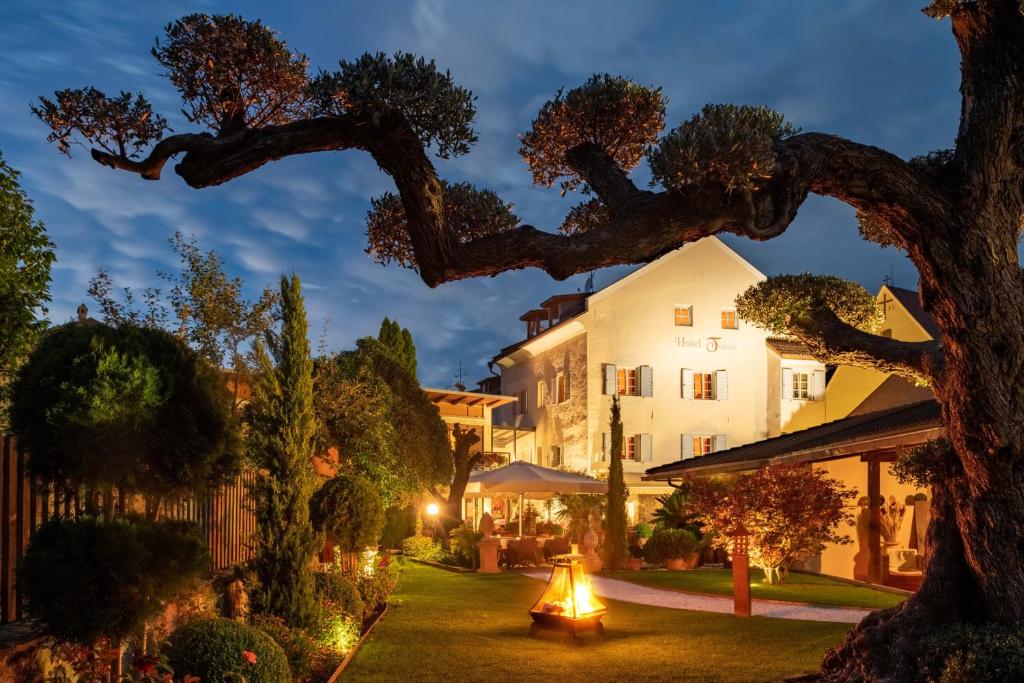 a view of a hotel at night with a tree at Hotel Traube in Bressanone