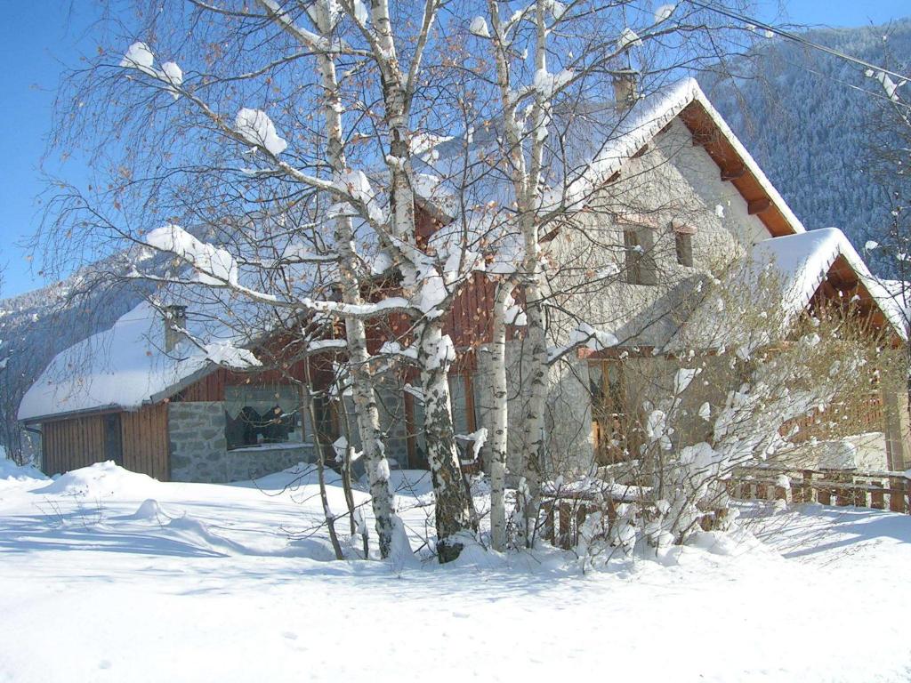 a snow covered house with a tree in front of it at Chambres d'hôtes l'Abondance in Pont-du-Fossé