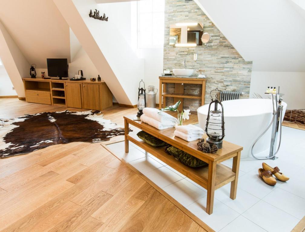 a bathroom with a bath tub and a table at Hôtel Spa Marotte in Amiens