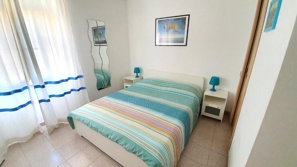 een kleine slaapkamer met een bed en een spiegel bij La Mandronia B&B in Alghero