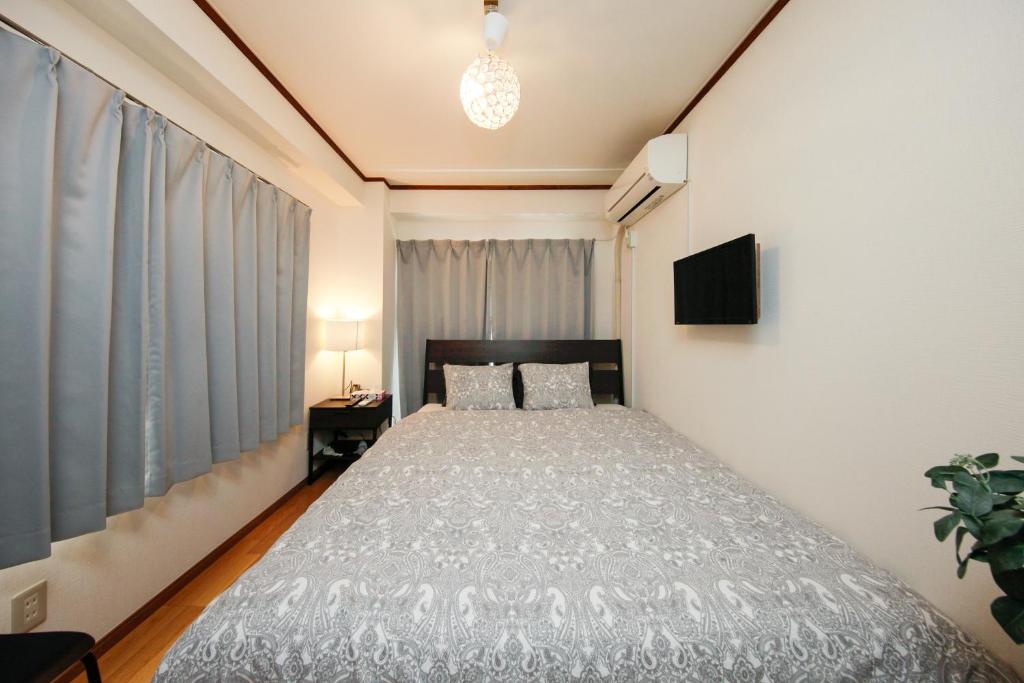 a bedroom with a bed and a television in it at Ikebukuro Apartment in Tokyo