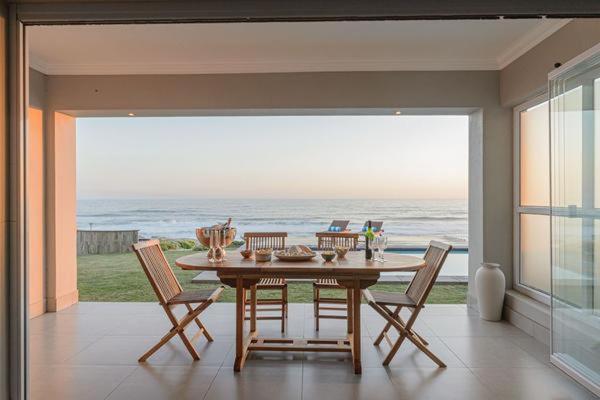 a dining room with a table and a view of the ocean at Ocean Breeze in Sea View