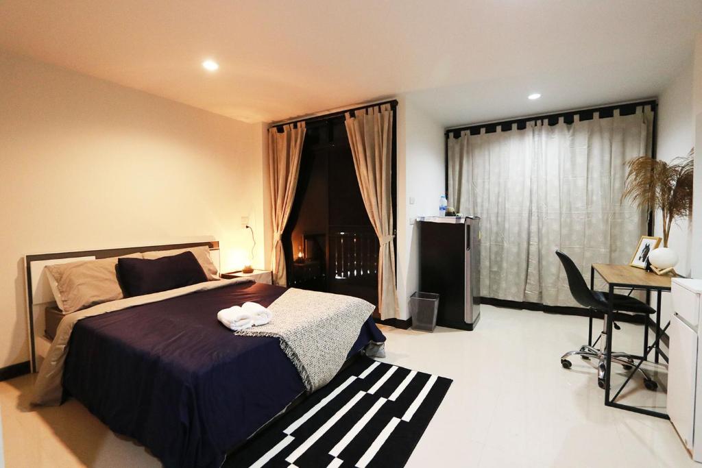 - une chambre avec un lit, un bureau et une fenêtre dans l'établissement Baanrao Bangson, à Bangkok