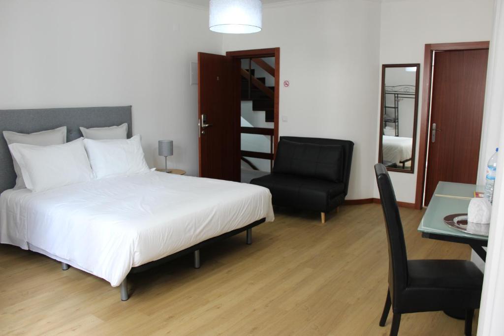 1 dormitorio con cama, silla y escritorio en Palmar Rooms, en Funchal