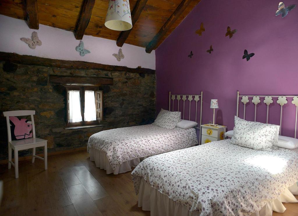 1 dormitorio con 2 camas y paredes moradas en La Casita de Leire, en Tamajón