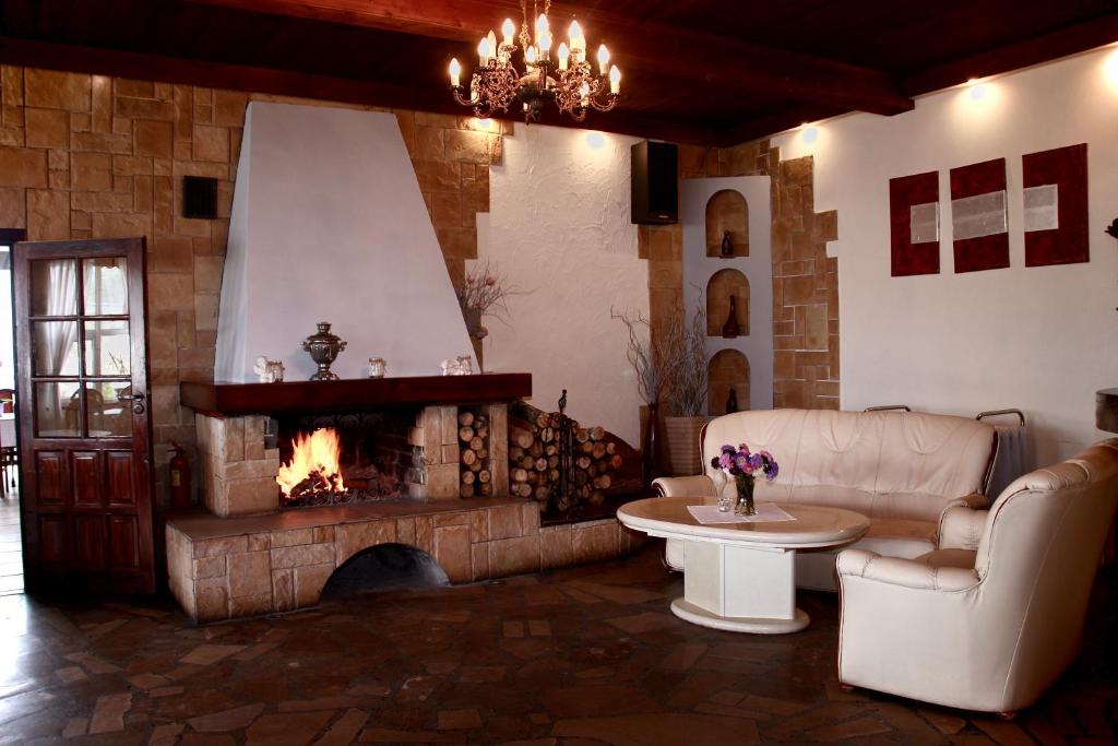 a living room with a fireplace and a couch and a table at Zajazd Pod Kominkiem - Brzoza koło Torunia in Toruń