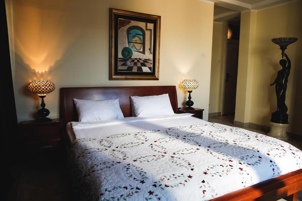 ein Schlafzimmer mit einem großen Bett mit zwei Lampen in der Unterkunft Hotel Bojatours in Podgorica