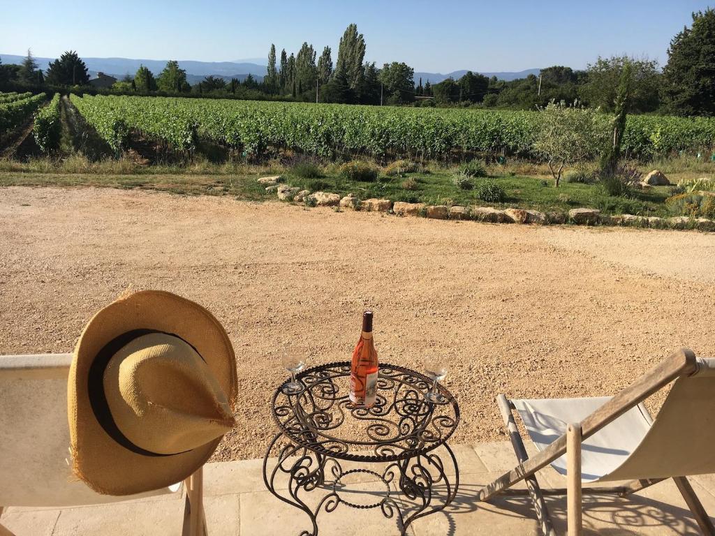 a hat sitting on a table with a bottle of wine at l'Ecurie in Bonnieux