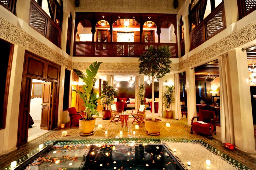 a large lobby with a pool in the middle of a building at Riad Belle Epoque in Marrakesh