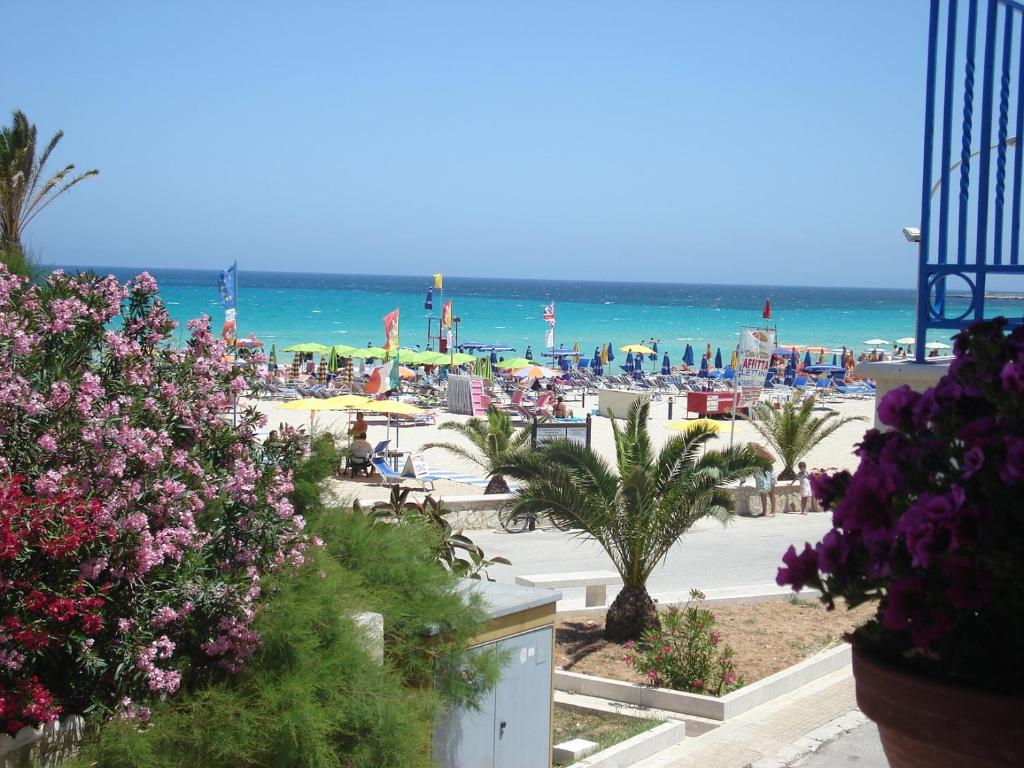 a beach with chairs and umbrellas and the ocean at Brezza Marina in San Vito lo Capo