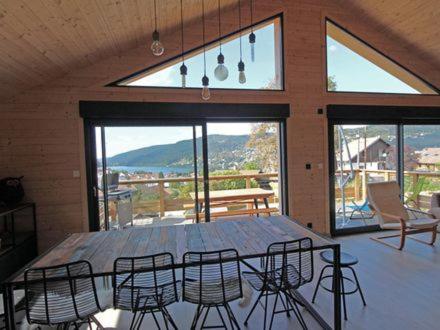 a dining table and chairs in a room with a view at l'Edelweiss in Gérardmer