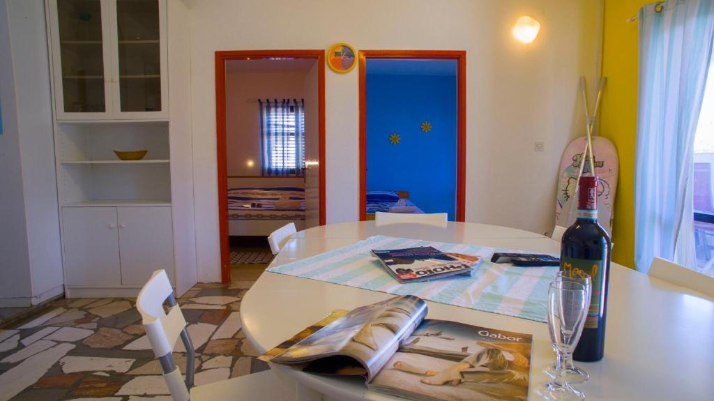 a white table with a bottle of wine on it at The Sea House Apartments in Vis