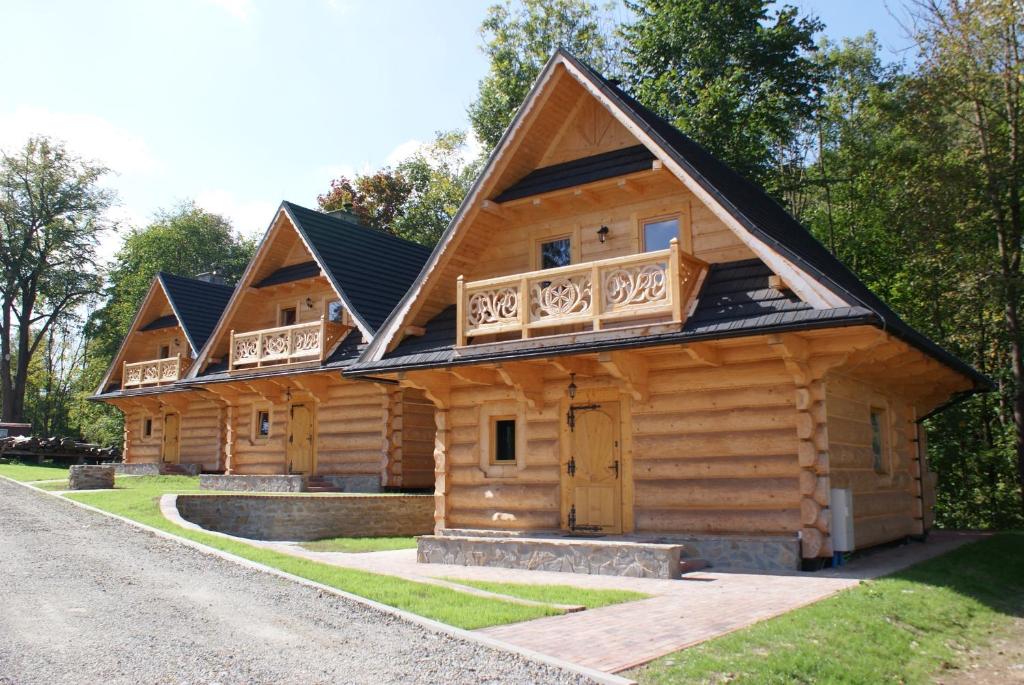 a log cabin with a gambrel roof at Ostoja Karlików - Domki do Wynajęcia in Bukowsko