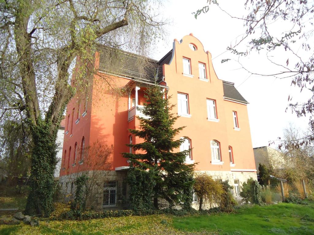 un grand bâtiment avec un arbre en face dans l'établissement Georgentor, à Naumbourg