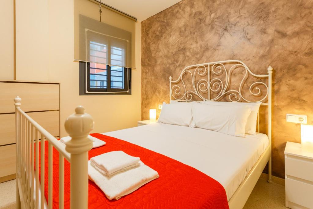 a bedroom with a white bed with a red blanket at Puerta San FELIX free parking by Cadiz4Rentals in Cádiz