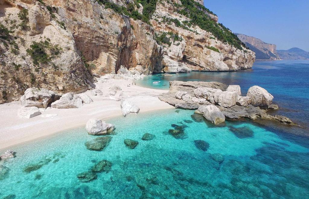 z góry widok na plażę z kamieniami i wodą w obiekcie Tesori di Sardegna w mieście Baunei