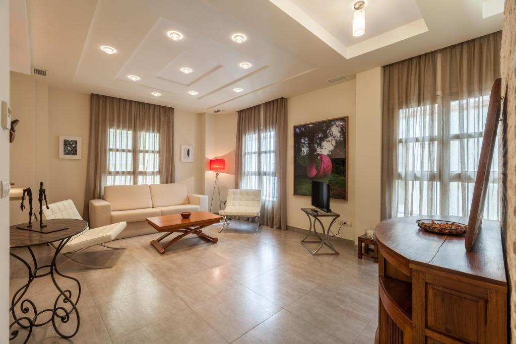 salon z kanapą i stołem w obiekcie Apartamento con encanto en el Barrio de Santa Cruz w Sewilli