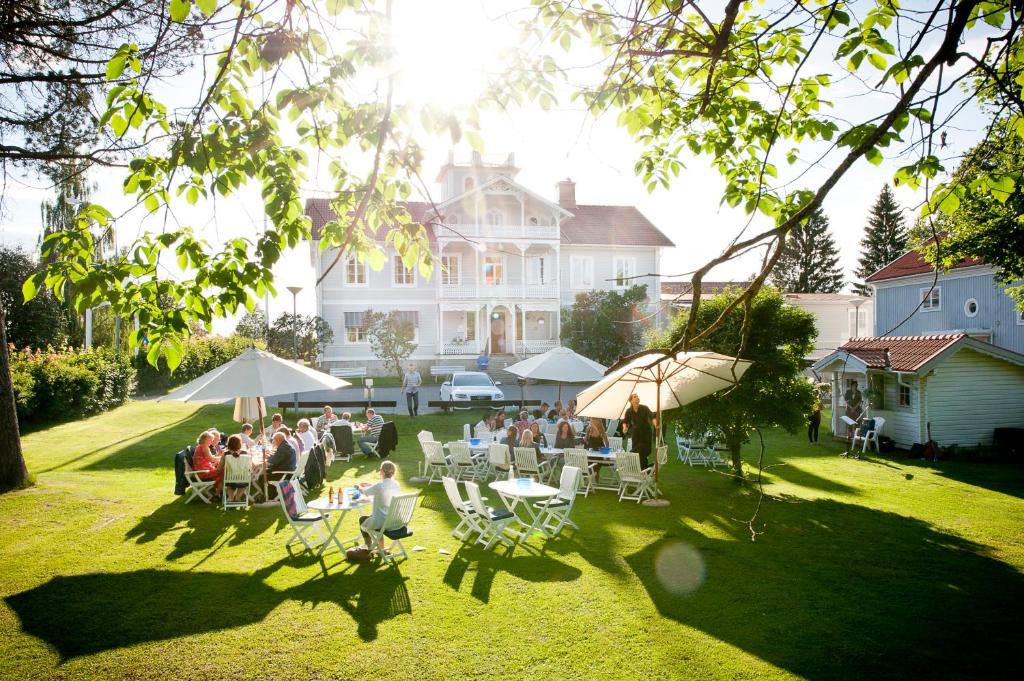 een groep mensen die aan tafels voor een huis zitten bij Gästisbacken in Alfta