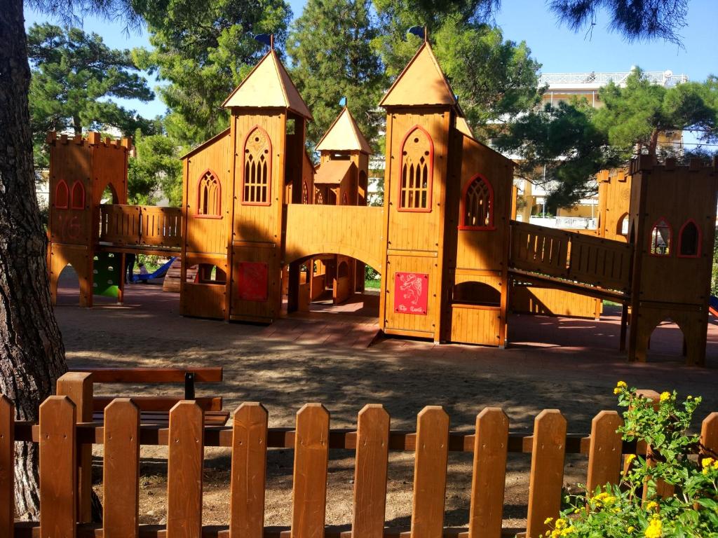 a large wooden play house with a wooden fence at Comfort apartment for small family in Loutraki