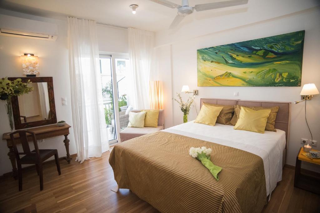 雅典的住宿－雅典衛城慵懶公寓，卧室配有一张床,墙上挂有绘画作品