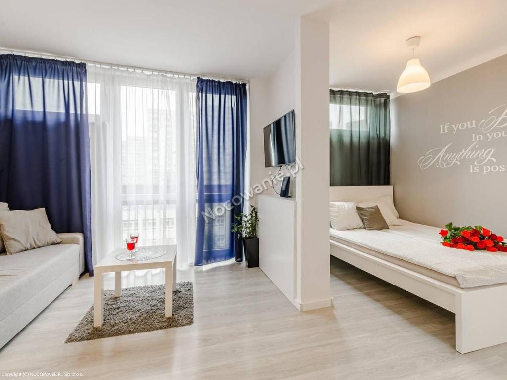 a white living room with a couch and a table at Apartment Oscar in Warsaw