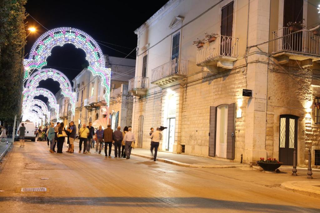 um grupo de pessoas andando por uma rua à noite em Casa Catalano em Terlizzi