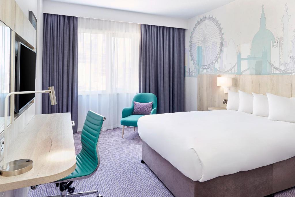 um quarto de hotel com uma cama grande e uma secretária em Leonardo Hotel London Croydon em Croydon
