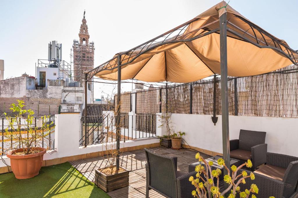 a patio with an umbrella on top of a building at Abades Giralda Suite by Valcambre in Seville