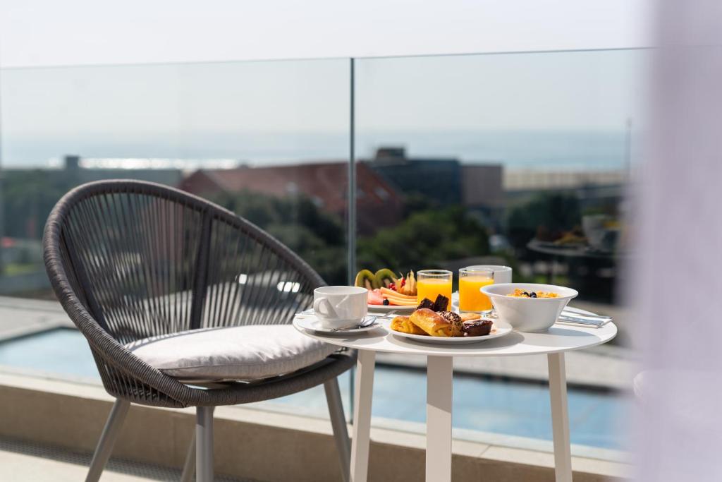 a table with a plate of food on a balcony at Eurostars Matosinhos in Matosinhos