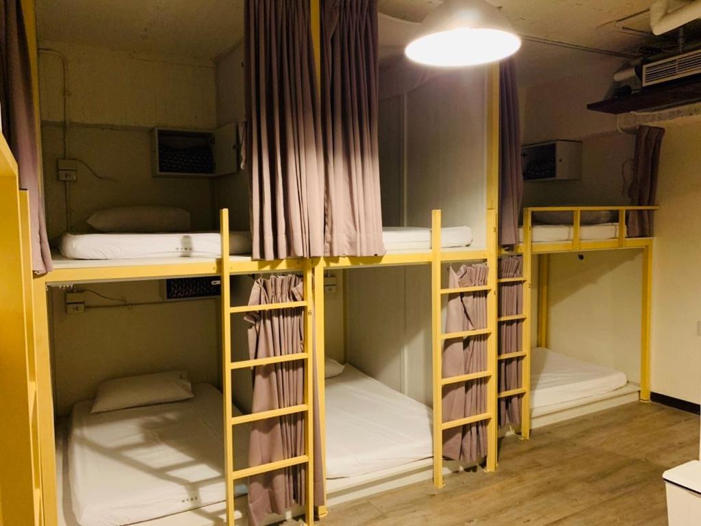 a room with three bunk beds in it at EasyInn Hotel &amp; Hostel in Tainan