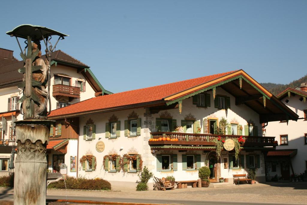 um grande edifício branco com um telhado vermelho em Ferienwohnung Jodlschmid em Ruhpolding