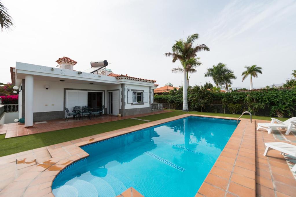 een zwembad voor een huis bij Villa Cosmos chalet con gran piscina y jardin privado in Maspalomas