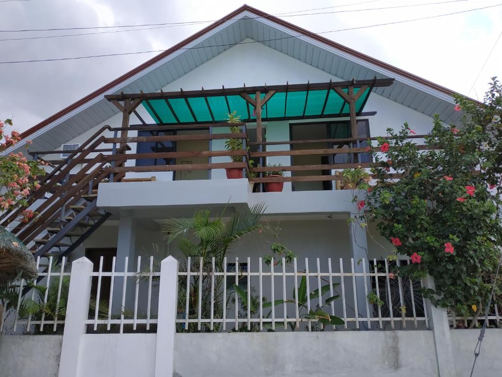 a house with a balcony and a fence at Hotel Sisters Inn in Moalboal