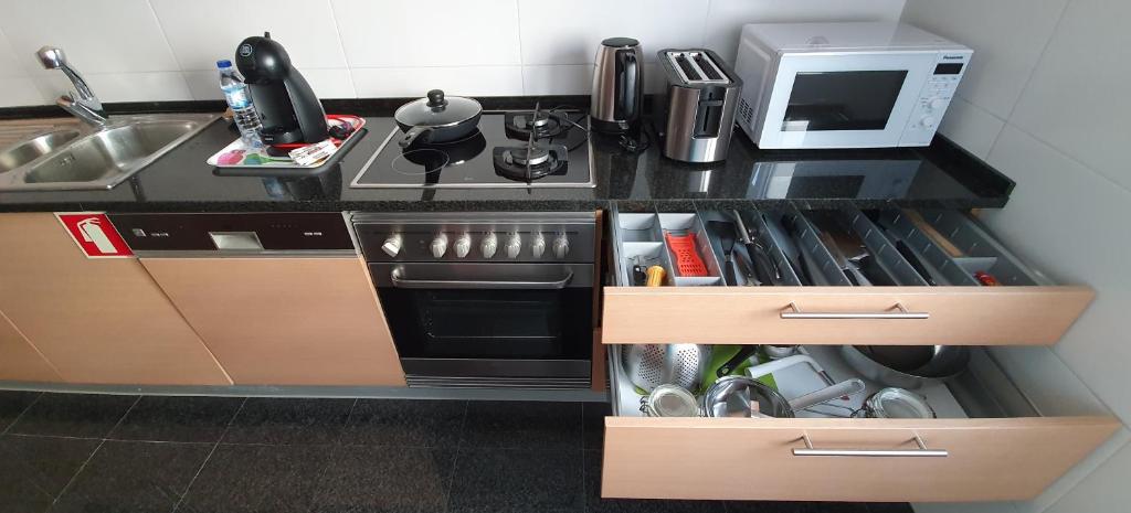 a small kitchen with a stove and a microwave at Sweethome in Lisbon