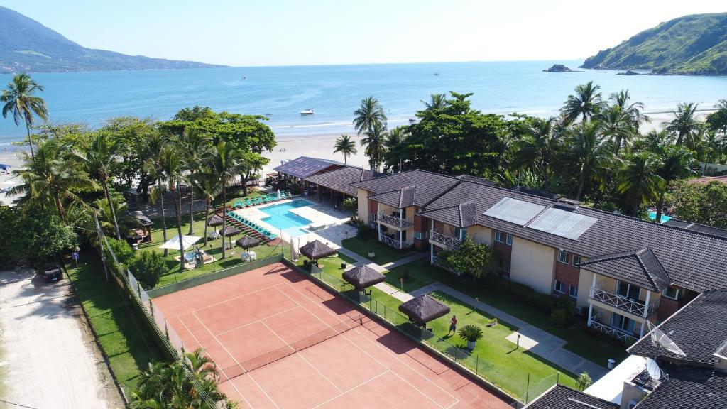 a beach with a pool and a house at Vistabela Resort & Spa in São Sebastião