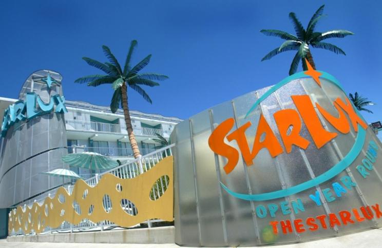 a sign in front of a building with palm trees at The StarLux in Wildwood