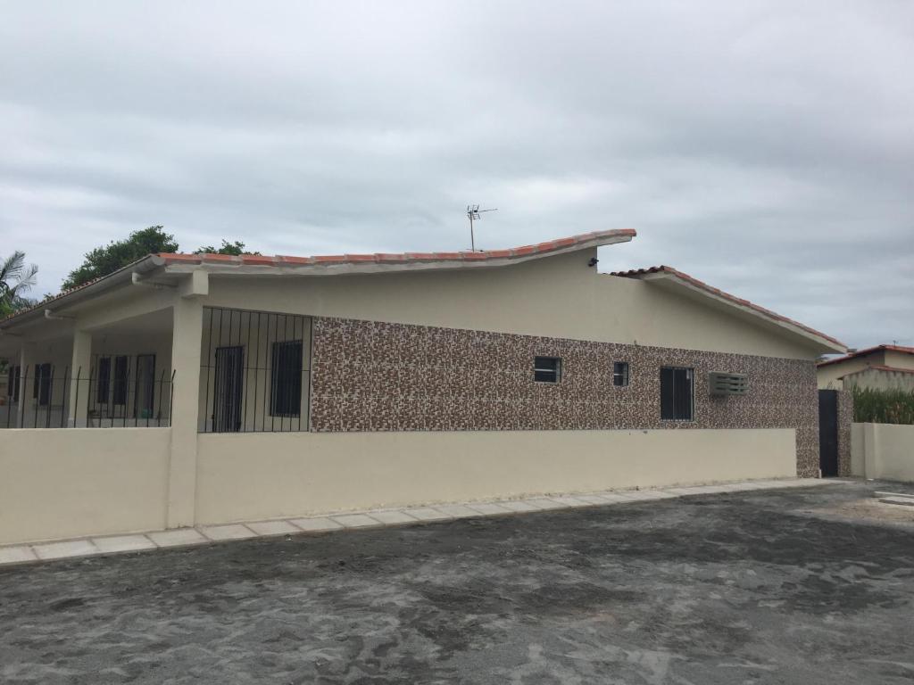 a house with a brick wall at Temporada Casa em Condomínio na Ilha de Itamaracá in Itamaracá